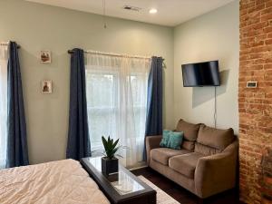 a living room with a couch and a tv at Cozy Gem Mins from U of L Hospital & Downtown in Louisville