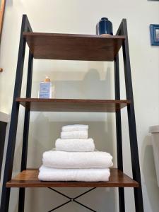 a stack of towels on a shelf in a bathroom at Cozy Gem Mins from U of L Hospital & Downtown in Louisville +33 photos