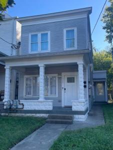 a gray house with a white door and a porch at Cozy Gem Mins from U of L Hospital & Downtown in Louisville