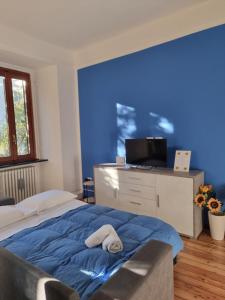 a blue bedroom with a bed with a towel on it at sunflower apartment in Domaso
