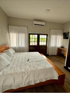 a bedroom with a large bed with white sheets at Arrendamientos portillo in Puerto Barrios