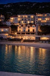 a building on the shore of a body of water at Solmare Neum Apartmani in Neum