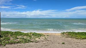 a view of the ocean from a sandy beach at Vila Ohana Beira Mar - Caraíva in Caraíva