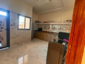 a kitchen with white marble floors and a window at شقق تاج الداخلة in Dakhla