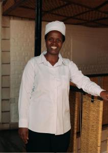 a man wearing a chef hat standing with his arms outstretched at Rwanda African Art Museum in Nyabisindu