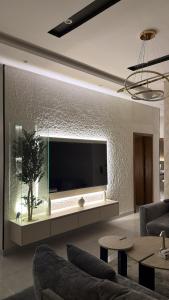 a living room with a large flat screen tv on a wall at شقه ثلاث غرف بحي المروه in Jeddah +9 photos
