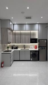 a large kitchen with stainless steel appliances and cabinets at شقه ثلاث غرف بحي المروه in Jeddah