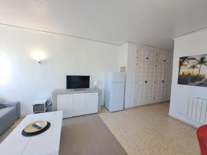 a living room with a couch and a refrigerator at Appartement El Palmar Denia in Denia