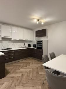 Eine Küche mit weißen Schränken und Holzboden in der Unterkunft Valina in Kozinšćak
