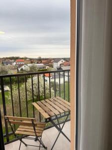 ein Balkon mit einem Holztisch und einer Bank in der Unterkunft Valina in Kozinšćak