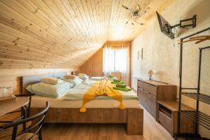 a bedroom with a large bed with a wooden ceiling at Pension Harmony in Bešeňová