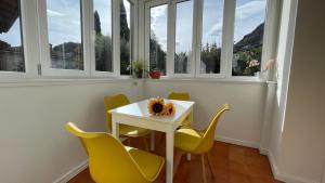 a white table and chairs in a room with windows at sunflower apartment in Domaso