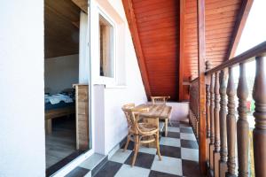 a room with a table and chairs on a porch at Pension Harmony in Bešeňová