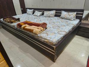 a bed with a wooden frame with a blanket on it at Hotel Vrindavan Near Prem Mandir Distance 15 min in Mathura