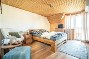 a bedroom with a bed and a chair at Pension Harmony in Bešeňová