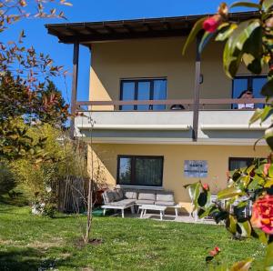 a house with a balcony with a couch in the yard at Gabi's Wolfühloase in Balerna