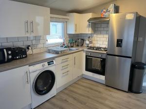 a kitchen with a stainless steel refrigerator and a dishwasher at Alberta holiday park in Whitstable