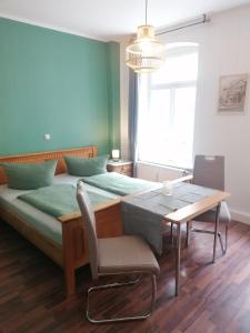 a bedroom with a bed and a table and a chair at Pension Gina in Görlitz
