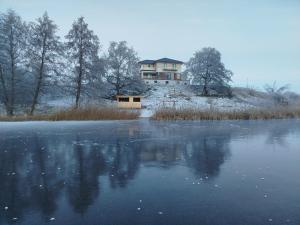 a house on top of a hill next to a lake at Malownicze Owieczki in Owieczki