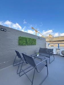 two chairs and a table on a roof at Modern Studio Apartment1 next to Valletta in Il-Furjana