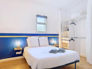 a bedroom with a white bed with a blue wall at Appartement Le Porto in Cholet