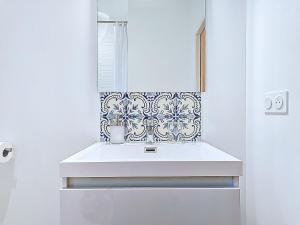 a white bathroom with a sink and a mirror at Appartement Le Porto in Cholet +21 photos