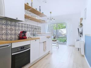 a kitchen with white cabinets and a large window at Appartement Le Porto in Cholet