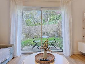 a living room with a table and a large window at Appartement Le Porto in Cholet