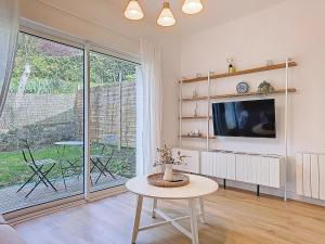 a living room with a tv and a table at Appartement Le Porto in Cholet