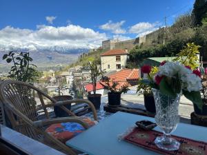a table with a vase of flowers sitting on a table at Manga guesthouse in Gjirokastër