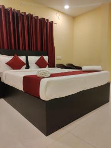 a large bed in a room with red curtains at VRS Residency in Mysore +48 photos