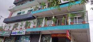 a building with a balcony with potted plants on it at VRS Residency in Mysore