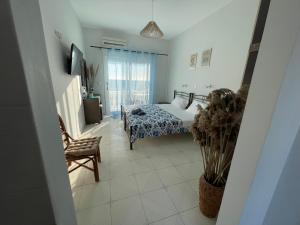 a bedroom with a bed and a chair at Thalassa apartments in Marathias