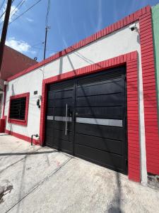 a garage with a black garage door on a building at suites ejecutivas centro guadalupe in Monterrey
