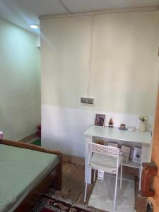 a bedroom with a desk and a bed and a chair at Lhamus homestay in Tawang