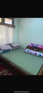 two twin beds sitting in a room with a window at Lhamus homestay in Tawang