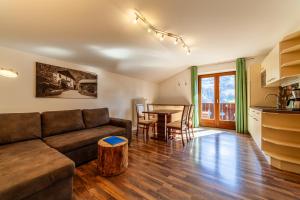 a living room with a couch and a table at Der Bognerhof - Ferienwohnungen mit beheiztem Salzwasserpool in Riffian bei Meran in Rifiano