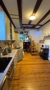a kitchen with wooden flooring and a large kitchen with a counter at Cottage - Kleine alte Villa am See in Bestensee
