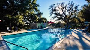 a swimming pool with blue water in a yard at The Sundance Tiny Home in Pauma Valley