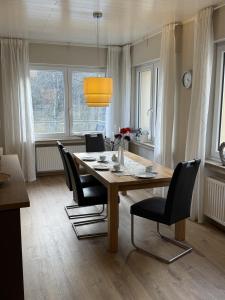 ein Esszimmer mit einem Holztisch und schwarzen Stühlen in der Unterkunft Haus Osterlämmchen in Ediger-Eller