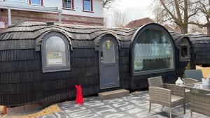 a black house with a door and a table and chairs at Seeperle Weißenstadt Haus Kornberg in Weißenstadt
