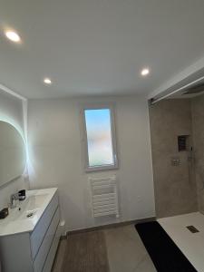 a white bathroom with a sink and a window at Appartement 2 pièces in Fréjus