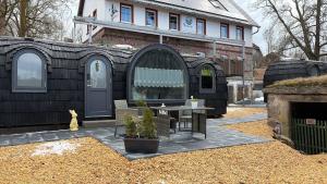 a black house with a table in front of it at Seeperle Weißenstadt Haus Kösseine in Weißenstadt