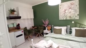 a bedroom with green walls and a bed and a kitchen at Studio Despoina in Skala Kallonis
