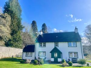 a white house with a black roof at Braemore Walled Garden in Garve +20 photos