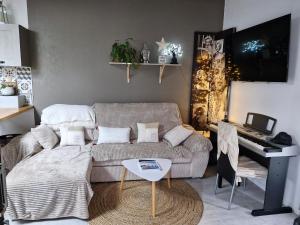 a living room with a couch and a piano at Mon havre de paix in Blésignac