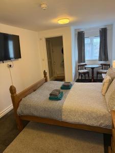 a bedroom with a bed with a flat screen tv at The BILLINGFORD HORSESHOES in Scole