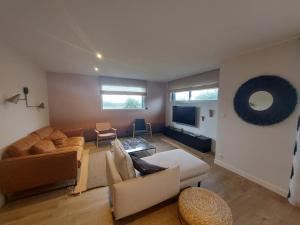 a living room with a couch and a tv at Maison à ROSCOFF avec vue mer in Roscoff