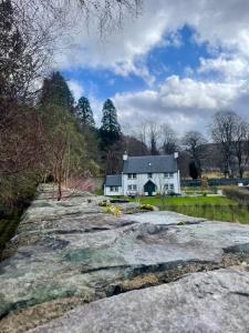 a white house in the middle of a field at Braemore Walled Garden in Garve