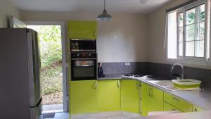 a kitchen with lime green cabinets and a refrigerator at VILLA Ti-COULANGE, Verdoyante in Rivière-Pilote